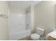 Bathroom showcasing a white tub/shower combo, toilet, neutral tile flooring and walls, and chrome hardware at 15814 Herring Gull Way, Charlotte, NC 28278