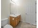 Bathroom vanity with a large mirror, neutral walls, cabinets with doors, and tile flooring at 15814 Herring Gull Way, Charlotte, NC 28278