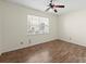 Bedroom featuring hardwood floors, a ceiling fan, neutral paint color, and a window for natural light at 15814 Herring Gull Way, Charlotte, NC 28278