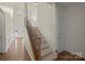 Inviting hallway with a staircase featuring iron spindles and a wooden handrail at 15814 Herring Gull Way, Charlotte, NC 28278