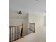 Upstairs loft area with neutral carpet, ceiling fan, neutral walls, and wooden banister overlooking the stairs at 15814 Herring Gull Way, Charlotte, NC 28278