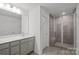 Bathroom features a modern vanity with grey cabinets and a large walk-in shower with tile surround at 15910 Parkside Crossing Dr # 318, Charlotte, NC 28278