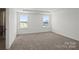 Bedroom has two windows with views, a tray ceiling, and neutral carpet at 15910 Parkside Crossing Dr # 318, Charlotte, NC 28278