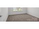 Bedroom features neutral carpet, natural light and views to the exterior at 15910 Parkside Crossing Dr # 318, Charlotte, NC 28278