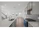 Bright, open kitchen with gray cabinets, island, and stainless steel gas range at 15910 Parkside Crossing Dr # 318, Charlotte, NC 28278