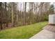 Backyard featuring a lawn with brick features and woods at 16631 Commons Creek Dr, Charlotte, NC 28277