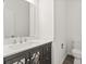 Stylish half bathroom featuring a dark vanity with modern sink and a mirror with decorative accents at 16631 Commons Creek Dr, Charlotte, NC 28277