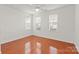 Bright bedroom with hardwood floors, three windows providing natural light, and neutral paint scheme at 16631 Commons Creek Dr, Charlotte, NC 28277