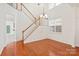 Inviting entryway featuring gleaming hardwood floors, a staircase, and a charming chandelier at 16631 Commons Creek Dr, Charlotte, NC 28277