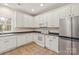 Well-lit kitchen with white cabinets, appliances, tile floor, and a window at 16631 Commons Creek Dr, Charlotte, NC 28277