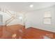Bright living room with hardwood floors, white walls, and a staircase leading to the second floor at 16631 Commons Creek Dr, Charlotte, NC 28277