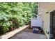View of the backyard, featuring a patio, lush trees, and the home's exterior with an AC unit at 168 Limerick Rd # C, Mooresville, NC 28115