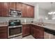 Well-lit kitchen features stainless steel appliances, granite countertops, and cherry wood cabinets at 168 Limerick Rd # C, Mooresville, NC 28115