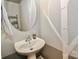 Charming powder room features a pedestal sink, round mirror, and stylish wallpaper at 168 Limerick Rd # C, Mooresville, NC 28115