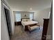 Spacious main bedroom featuring plush carpeting, a decorative bench, and an abundance of natural light at 1843 Old Rivers Rd # 209, Concord, NC 28027