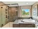 Bathroom showcasing a glass-enclosed shower, soaking tub, and a large window with natural light at 2009 Autumn Dr # 2, Monroe, NC 28110