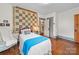 Cozy bedroom with a quilt, hardwood floors, and a chair at 208 Park Ave, Wadesboro, NC 28170
