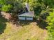 Two-car detached garage with white doors, nestled among shady trees in a backyard setting at 208 Park Ave, Wadesboro, NC 28170