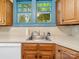 Well-lit kitchen featuring updated countertops, stainless steel sink and classic wood cabinetry at 208 Park Ave, Wadesboro, NC 28170