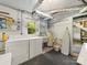 Functional laundry room with washer, dryer, utility sink, shelving, and a view to the backyard at 208 Park Ave, Wadesboro, NC 28170