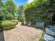 Outdoor patio features brick pavers, wrought iron furniture and mature landscaping at 208 Park Ave, Wadesboro, NC 28170