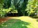 Backyard featuring a large grassy area and many mature trees at 211 Worthington St, Shelby, NC 28150