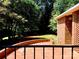 Landscaped backyard featuring a brick patio, beautiful lawn, and lush trees at 211 Worthington St, Shelby, NC 28150