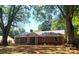 Charming brick ranch home featuring a well-manicured lawn and mature trees at 211 Worthington St, Shelby, NC 28150