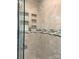 Detailed view of the glass enclosed shower with custom tiled walls and in-set shelving at 211 Worthington St, Shelby, NC 28150