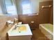 Classic bathroom features a white sink, toilet, and bathtub with retro tiling and fixtures at 215 E K St, Newton, NC 28658