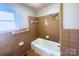 Bathroom with a vintage aesthetic, showcasing brown tiles, a bathtub, and classic fixtures at 215 E K St, Newton, NC 28658