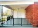 A charming, covered brick front porch with black metal railings at 215 E K St, Newton, NC 28658