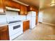 Charming kitchen featuring wood cabinets and white appliances providing ample storage and functionality at 215 E K St, Newton, NC 28658