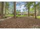 Private wooded backyard featuring mature trees, a stone walkway and beautiful landscaping at 2600 Gemway Dr, Charlotte, NC 28216