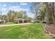 Expansive backyard featuring an oversized lawn, mature trees, and partial rock border landscaping at 2600 Gemway Dr, Charlotte, NC 28216