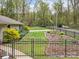 Well-maintained backyard features lush lawn, mature trees, iron fence, and manicured landscaping at 2600 Gemway Dr, Charlotte, NC 28216