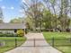 Spacious driveway and backyard are enclosed by an iron fence, mature trees and a lush green lawn at 2600 Gemway Dr, Charlotte, NC 28216