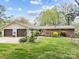 Well-maintained house with two-car garage, brick accents, and an expansive green lawn at 2600 Gemway Dr, Charlotte, NC 28216