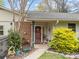 Inviting front porch with brick accents, a bright red door, and charming decorative landscaping at 2600 Gemway Dr, Charlotte, NC 28216
