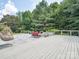 A spacious backyard patio featuring a fire pit, lounge chairs, hanging swing chair, and lush greenery providing privacy at 2751 Collaroy Rd, Waxhaw, NC 28173