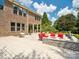 A brick house featuring a large backyard patio with a fire pit, outdoor seating, and a hanging swing chair at 2751 Collaroy Rd, Waxhaw, NC 28173