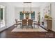 Bright dining room features a wooden dining table, rug, decorative lighting fixture and large windows at 2751 Collaroy Rd, Waxhaw, NC 28173