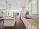 Modern kitchen with white cabinets, granite countertops, stainless steel appliances, and hardwood floors, seamlessly connecting to living area at 2751 Collaroy Rd, Waxhaw, NC 28173