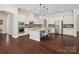 Elegant kitchen featuring white cabinetry, a center island with seating, stainless steel appliances and hardwood floors at 2751 Collaroy Rd, Waxhaw, NC 28173