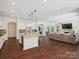 Open concept kitchen with granite island, stainless appliances, and seamless flow to the living room at 2751 Collaroy Rd, Waxhaw, NC 28173