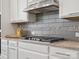 Modern kitchen featuring stainless steel appliances, gray tile backsplash, and ample white cabinet space at 2751 Collaroy Rd, Waxhaw, NC 28173