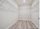 An organized walk-in closet with white wire shelving and wood-look floors at 2751 Collaroy Rd, Waxhaw, NC 28173