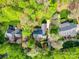 Aerial view of a brick home nestled among mature trees with lush landscaping and manicured grounds at 3667 Saint Andrews Ln, Gastonia, NC 28056