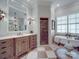Bright bathroom featuring a clawfoot tub, tiled floors, arched doorway, and vanity at 3667 Saint Andrews Ln, Gastonia, NC 28056