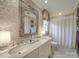 Bathroom featuring vintage mirror, vanity with dual sinks, toilet, and decorated wallpaper at 3667 Saint Andrews Ln, Gastonia, NC 28056